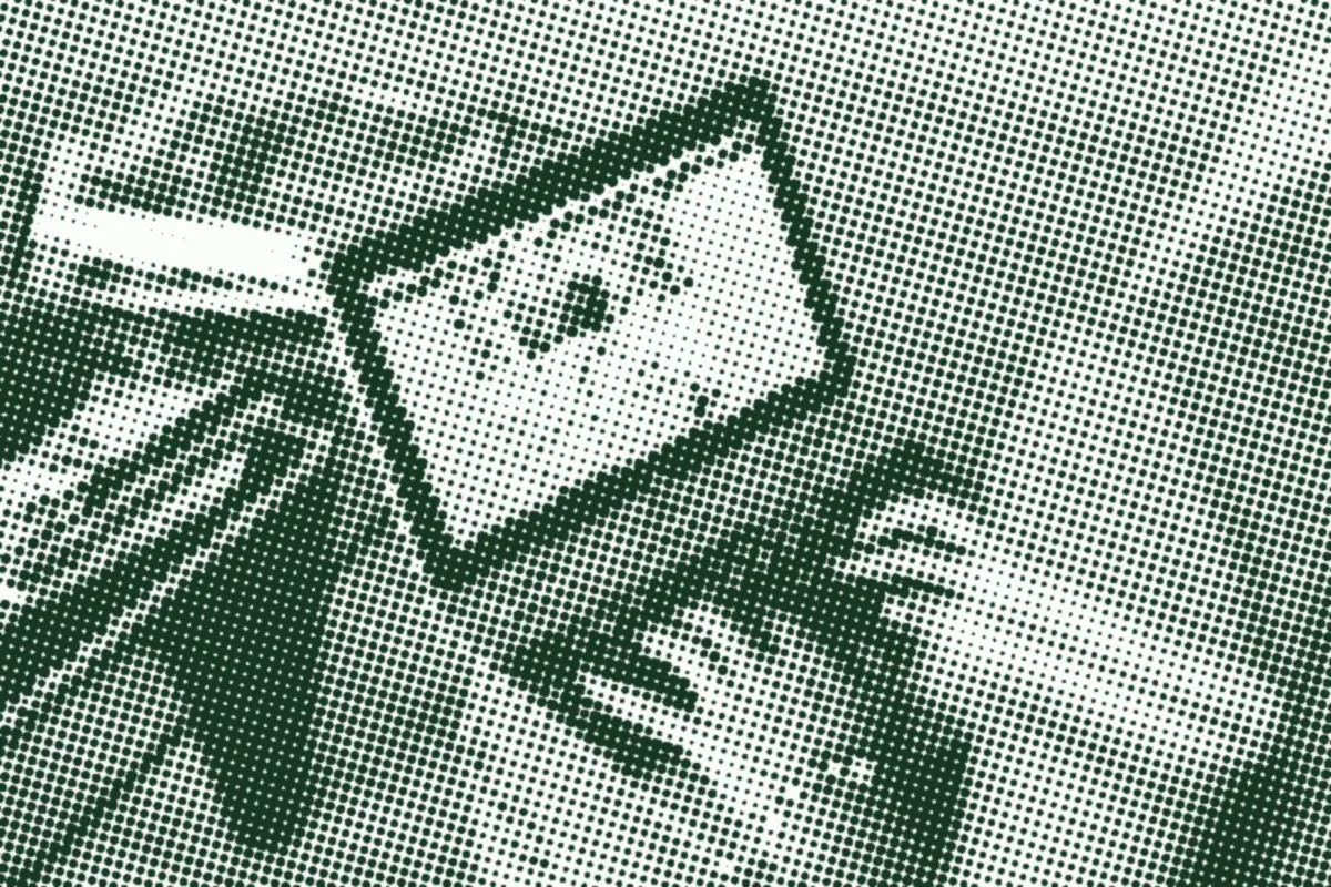 Hands using a laptop beside an open notebook.